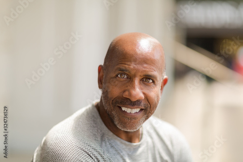 Happy mature African American man smiling outside.