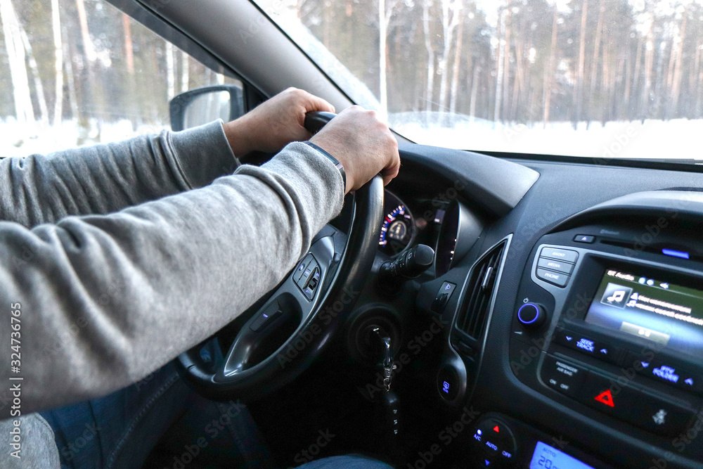 man holds the steering wheel firmly with both hands