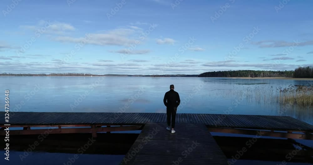 Sany day in winter time, man crosses a bridge Sany day in winter time, man crosses a bridge