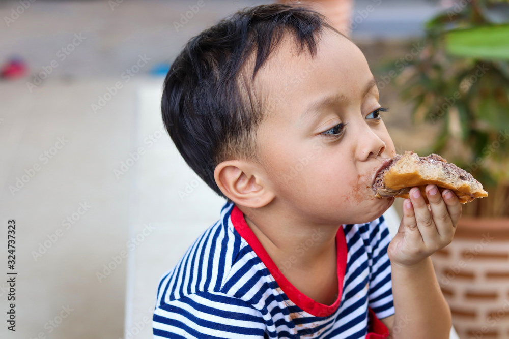 Little boy eating chocolate ice cream with bread, Child Mouth Smeared with Chocolate. Little boy eating chocolate ice cream with bread, Child Mouth Smeared with Chocolate.