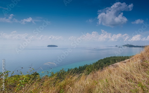 Mountain view of pine forest seaside with Lipe island in blue-green sea and blue sky background  taken from Chado Cliff view point  Adang island  Tarutao Marine National Park  Satun  southern Thailand