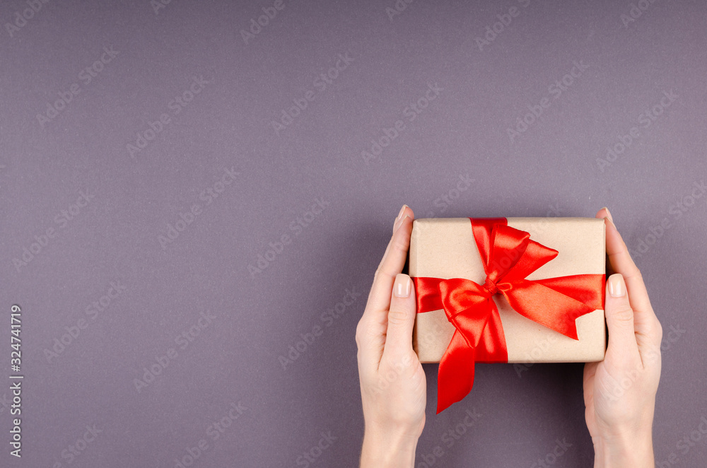 Hands with gift box on dark background composition, present with ribbon and bow. Hands with gift box on dark background composition, present with ribbon and bow.