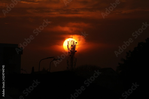 Fototapeta Naklejka Na Ścianę i Meble -  silhouette picture of cellphone tower on the sunset. sunset behind cellphone tower with red sky