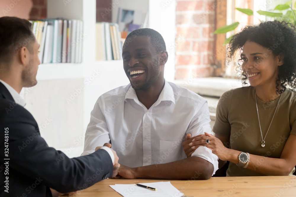 Happy African American couple handshaking manager, realtor, making deal Happy African American couple handshaking manager, realtor, making deal