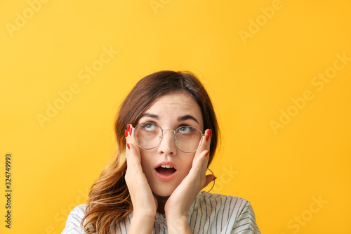 Fotografija Surprised woman with stylish eyeglasses on color background