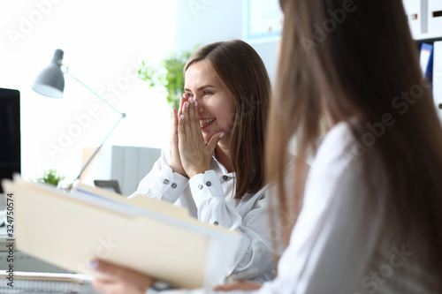 Portrait of happy businesswoman sitting in modern office and discussing important charts and graphs in significant paper tablet. Accounting workplace concept