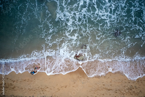 Aerial View of Waves and Azure beach with rocks. Kerala, India.