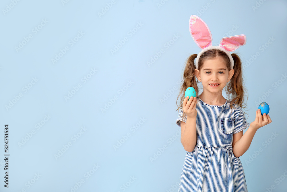 Little girl with Easter eggs and bunny ears on color background Little girl with Easter eggs and bunny ears on color background
