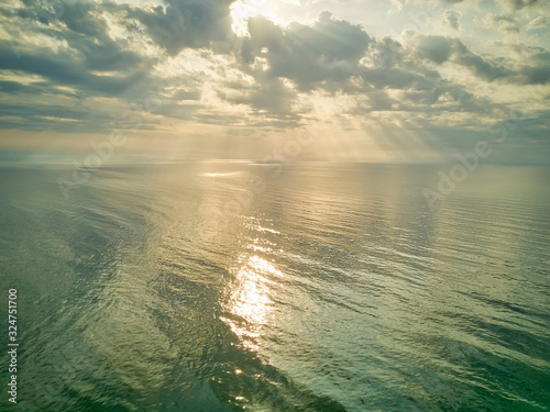 Aerial view of a Sunrise sky background. Aerial Dramatic gold sunrise with morning sky clouds over the sea. Stunning sky clouds in the sunrise. Aerial photography. © Igor Syrbu