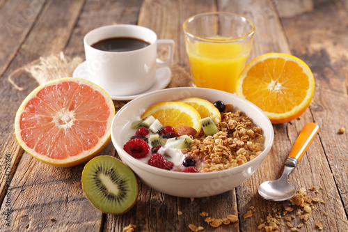 healthy breakfast with muesli and fruit, coffee cup and orange juice