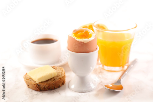 boiled egg, toast with butter, coffee cup and orange juice