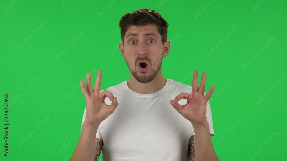 Portrait of confident guy is making sign ok. Green screen Portrait of confident guy is making sign ok. Green screen