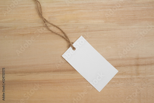Mock up white tags for clothes on a wooden background. Empty place for an inscription. Shop and sale.