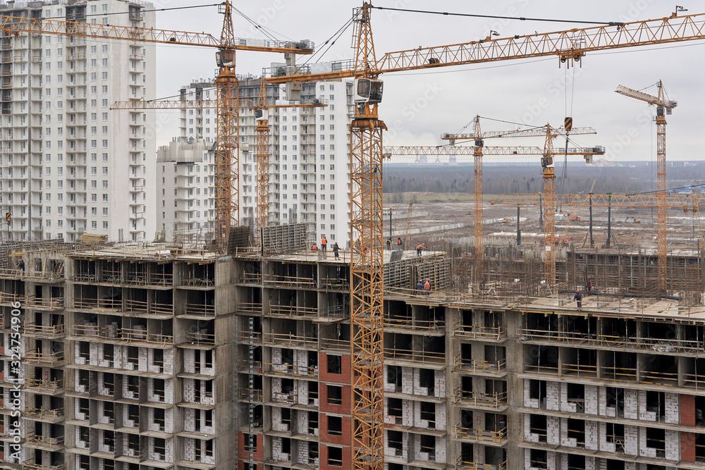 A lot of builders in helmets and masks on the top floor of a house under construction