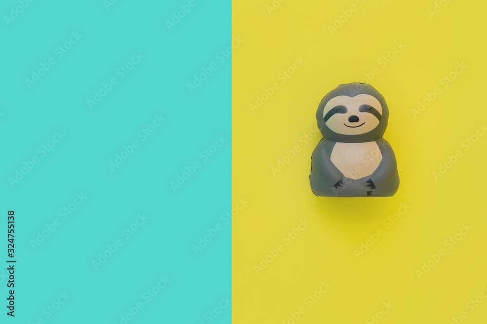 Flat lay antistress toy squish gray sloth with mouth, eyes, nose. Bright yellow and blue background.Compressing, soft, squeezable items to relieve stress, problems, anxieties, worries.Summer concept Flat lay antistress toy squish gray sloth with mouth, eyes, nose. Bright yellow and blue background.Compressing, soft, squeezable items to relieve stress, problems, anxieties, worries.Summer concept