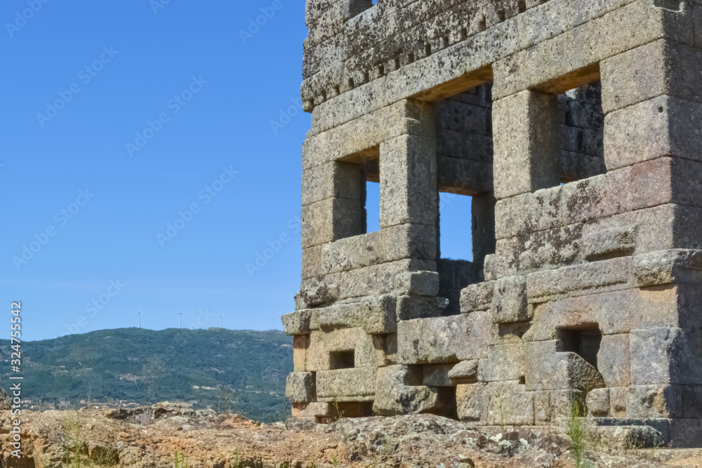 View at the exterior front facade of medieval Saint Cornélio tower, woman looking the building, iconic ruins monument building at the Belmonte village, portuguese patrimony
