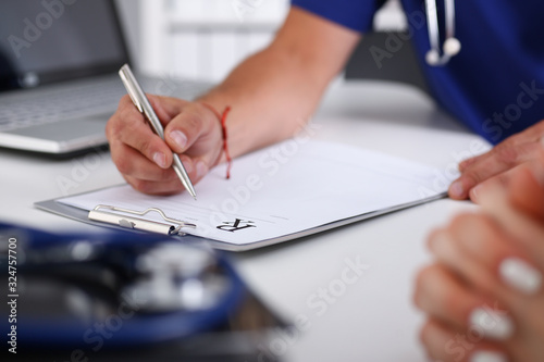 Male doctor hand write prescription at office worktable using silver pen. Panacea life save prescribing antidepressant legal drug store vitamin aid ward round give or take potion concept