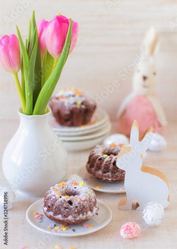 beautiful vintage easter table decoration with  mini bundt cake and flowers in pastel colors photo