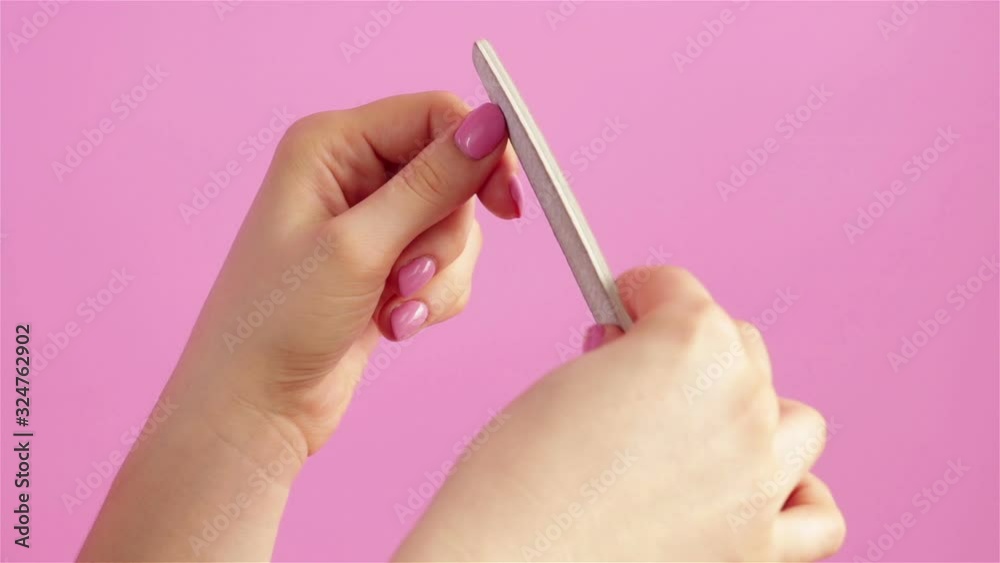 woman hands doing manicure with nail file close up woman hands doing manicure with nail file close up