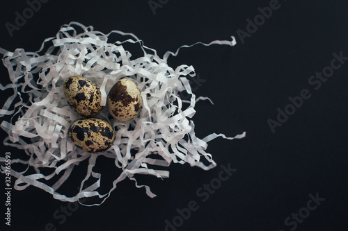 Quail eggs on black background. Easter backdrop. 