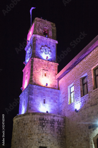 Night view of the clock tower of Wolfson Community Center building in a square in the old city of Safed in northern Israel photo