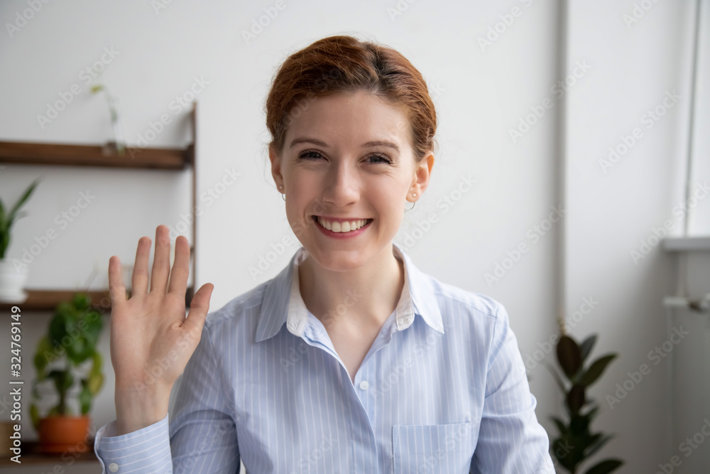 Head shot portrait of attractive smiling businesswoman waving hand Head shot portrait of attractive smiling businesswoman waving hand