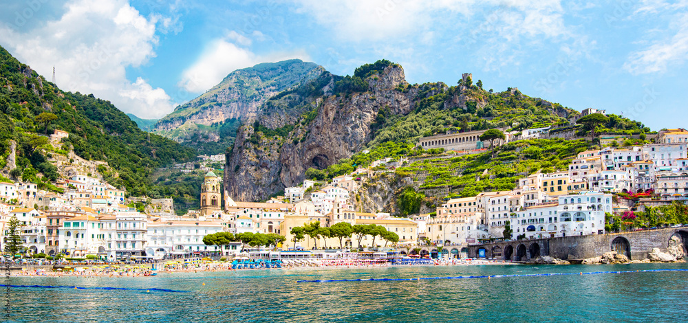 Panoramic view of small haven of Amalfi village with turquoise sea and colorful houses on slopes of Amalfi Coast with Gulf of Salerno, Campania, Italy.