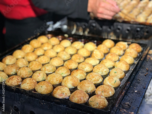 Takoyaki or ball-shaped Japanese snack sold at Kuromon market in Osaka, Japan. photo