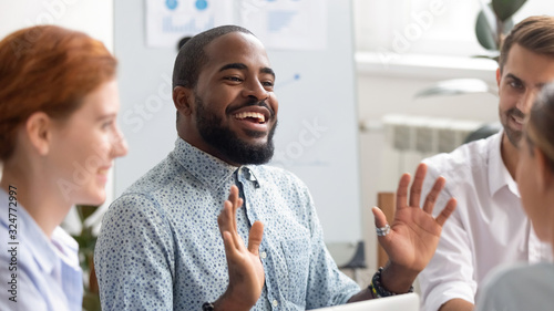 Smiling African American businessman chatting with colleagues in boardroom