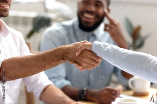 Close up businessman shaking hand of business partner at meeting