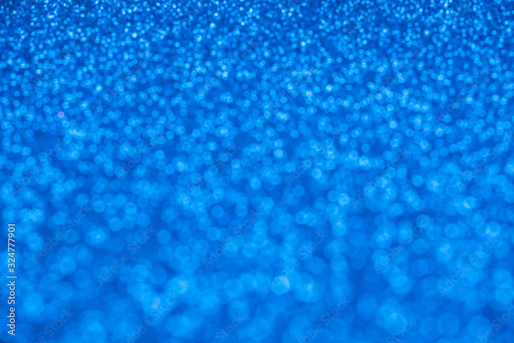Blue glitter in defocus. Blurred background, stylish abstraction