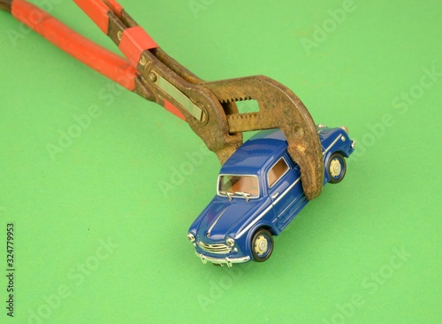 rottamazione delle auto più inquinanti: vecchia auto a benzina che sta per essere schiacciata da una una vecchia pinza 