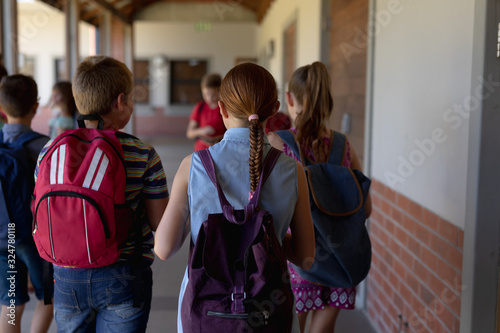 Group of schoolchildren walking in an outdoor corridor at elementary school