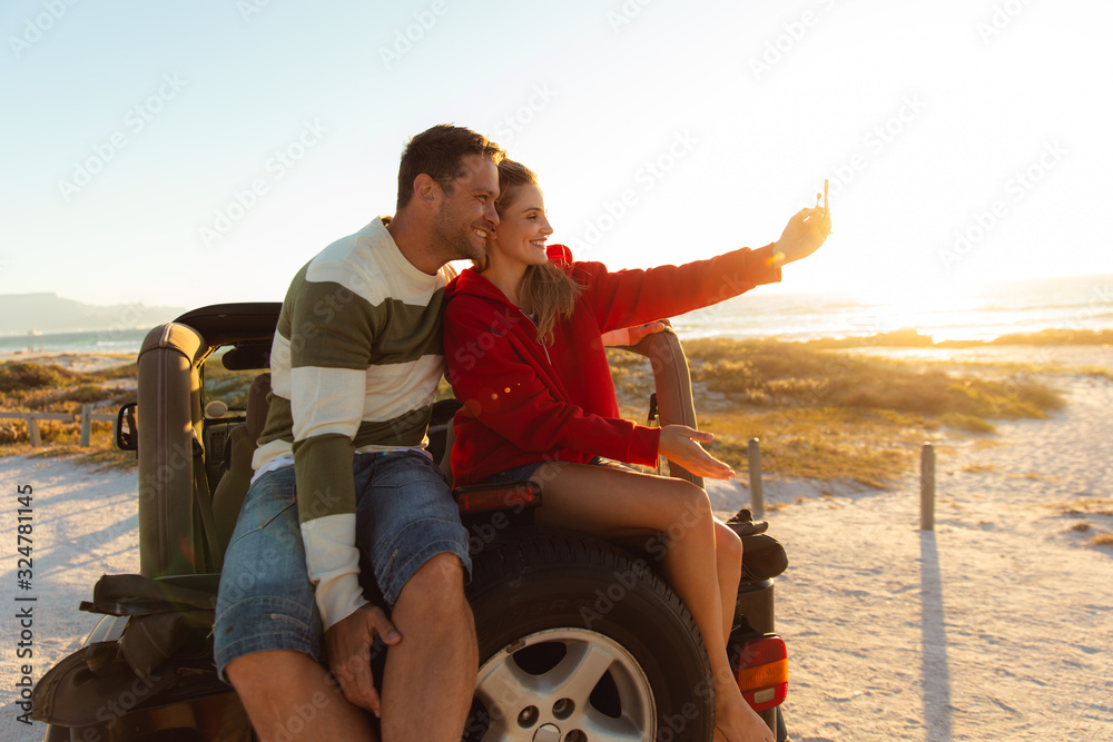 Couple taking photos on a car Couple taking photos on a car