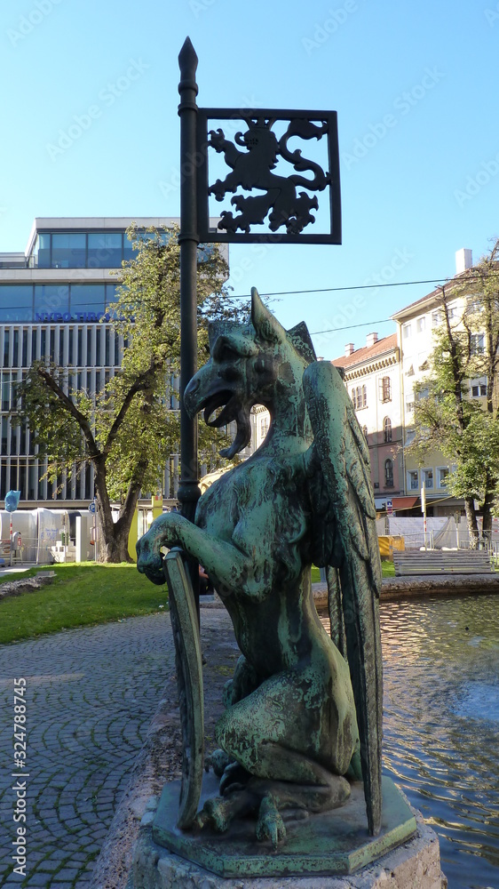 Naklejka premium Old marble statue depicting evil form located in the city center, bright sunny day