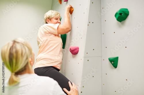 Senior Frau beim Klettern in einer Kletterhalle photo