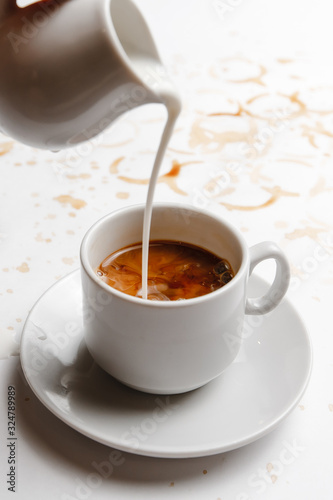 cream is poured into black coffee on a white background filled with coffee. a place for a label