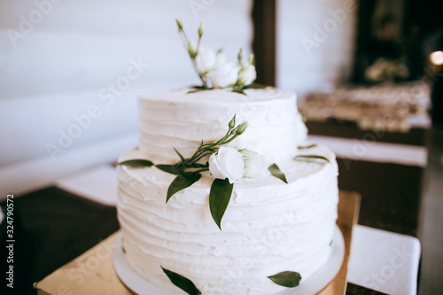 Beautiful delicious white wedding cake with white roses. Sweet food