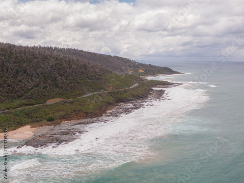 Beach view along Great Ocean Road. Beautiful ocean from road along coast  with beach. Blue ocean sea  white sand  mountain landscape. Travel  roadtrip  holiday  vacation  journey  paradise. Australia.