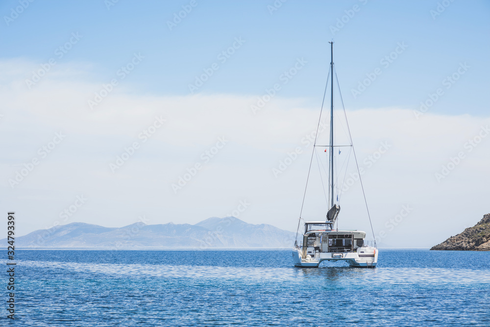 Beautiful bay with sailing boat yacht catamaran. Sail boat in a mediterranean sea. Yachting, travel, active lifestyle, summer fun and enjoying life concept