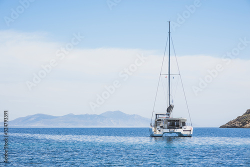 Beautiful bay with sailing boat yacht catamaran. Sail boat in a mediterranean sea. Yachting, travel, active lifestyle, summer fun and enjoying life concept © kite_rin