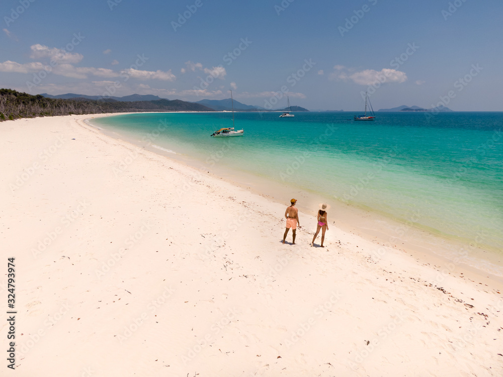 Couple on honeymoon on beach. Whitsundays aerial view, with turquoise ocean, white sand. Dramatic DRONE view from above. Travel, holiday, vacation, paradise. Shot in Whitsundays Islands, Queenstown, A