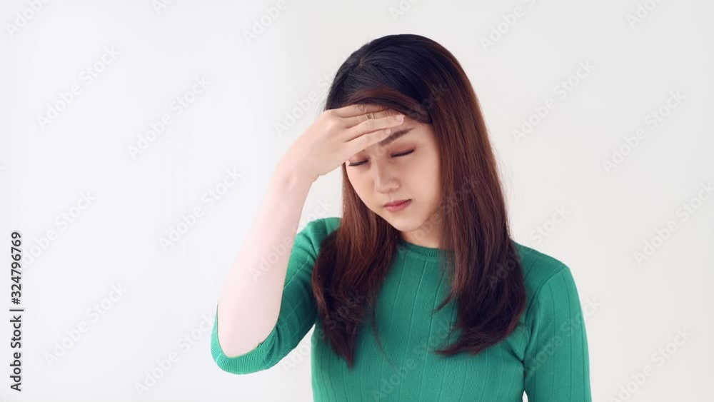 Portrait of young woman keeping hand on head, headache over isolated light background. People sincere emotions, lifestyle concept Portrait of young woman keeping hand on head, headache over isolated light background. People sincere emotions, lifestyle concept