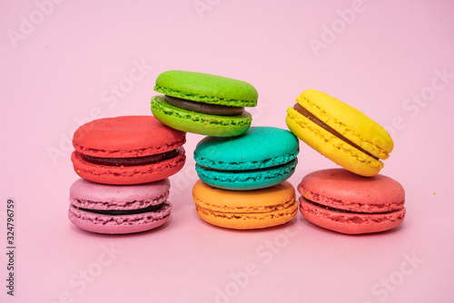 Multicolored macaroons on pink background. Sweet and colourful french macaroons