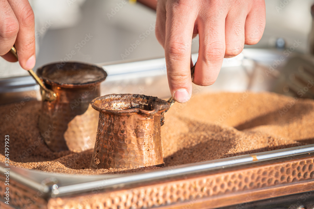Preparation of Turkish coffee in the cezve in the sand