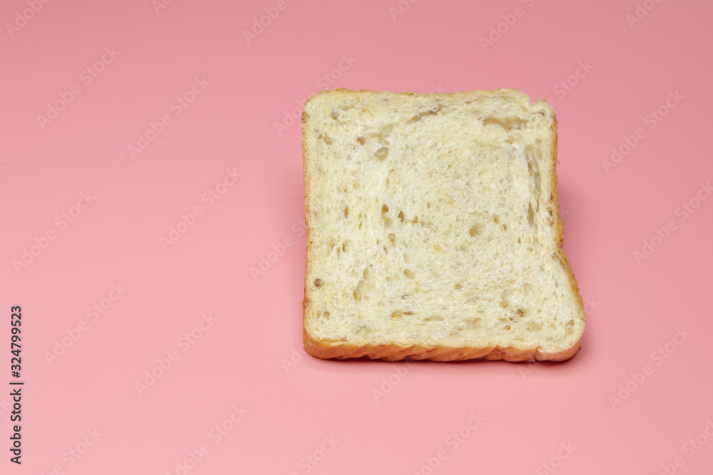 Slice of bread on a pink background. Close-up. Concept: breakfast, farm, restaurant, cafe