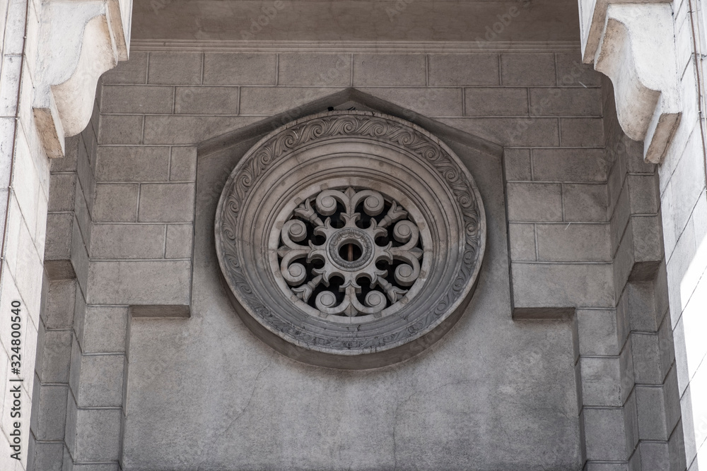 Decorative round element of facade building...Decorative ventilation hole above the main entrance of old building.