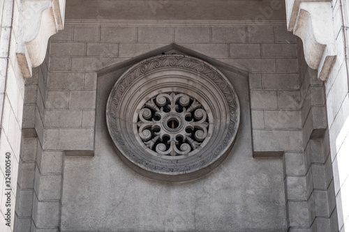 Decorative round element of facade building...Decorative ventilation hole above the main entrance of old building.