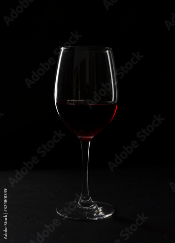 Closeup of glass of wine against dark baclground. Alcohol beverage