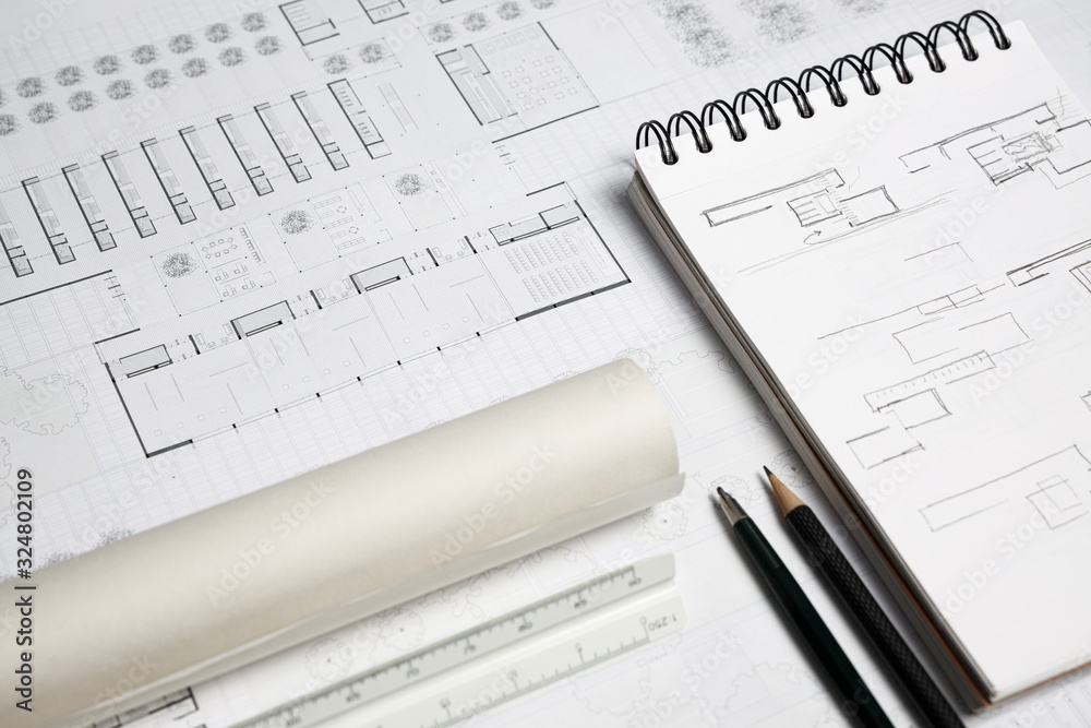 Architect scale ruler, pencil, mechanical pencil, notebook and building blueprint on worktable Architect scale ruler, pencil, mechanical pencil, notebook and building blueprint on worktable